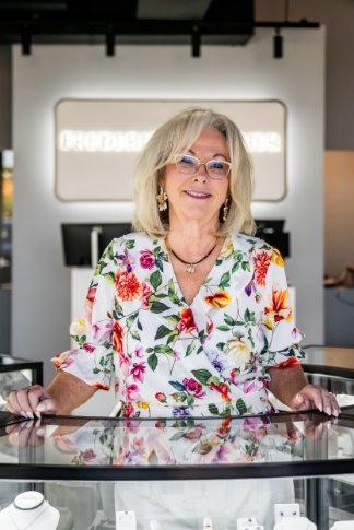 Store Manager, Terry, standing with jewelry displays at the new Frederick Fisher Jewelers Glendale location. 