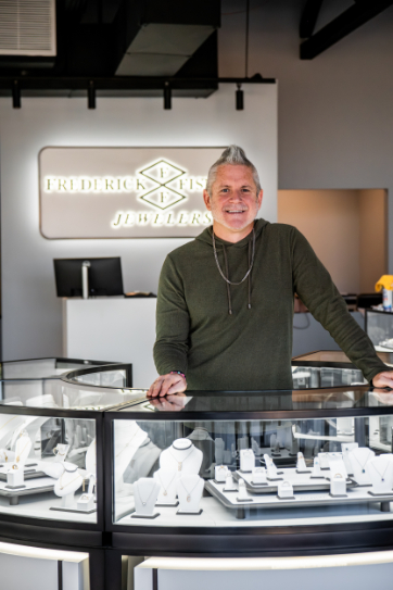Owner of Frederick Fisher Jewelers, standing with jewelry in new location, now open in Glendale, Arizona